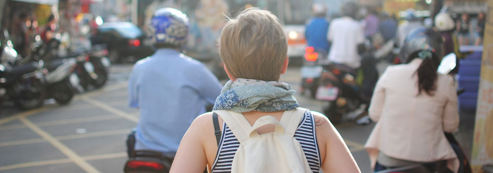 Shot from behind of a woman walking through a busy street.